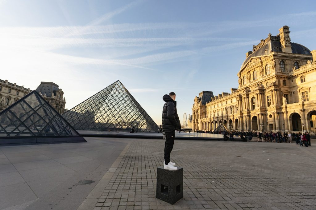 A man standing on top of a box in front of a pyramid