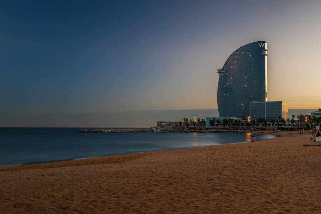 A view of a beach with a very tall building in the background