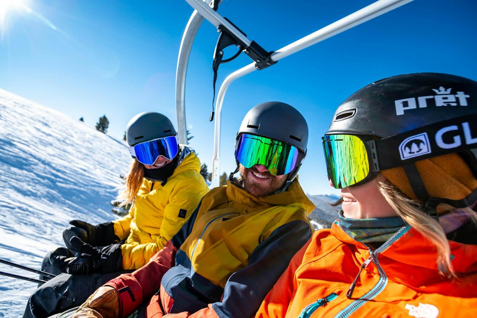 2 person in yellow jacket wearing helmet riding on cable car during daytime